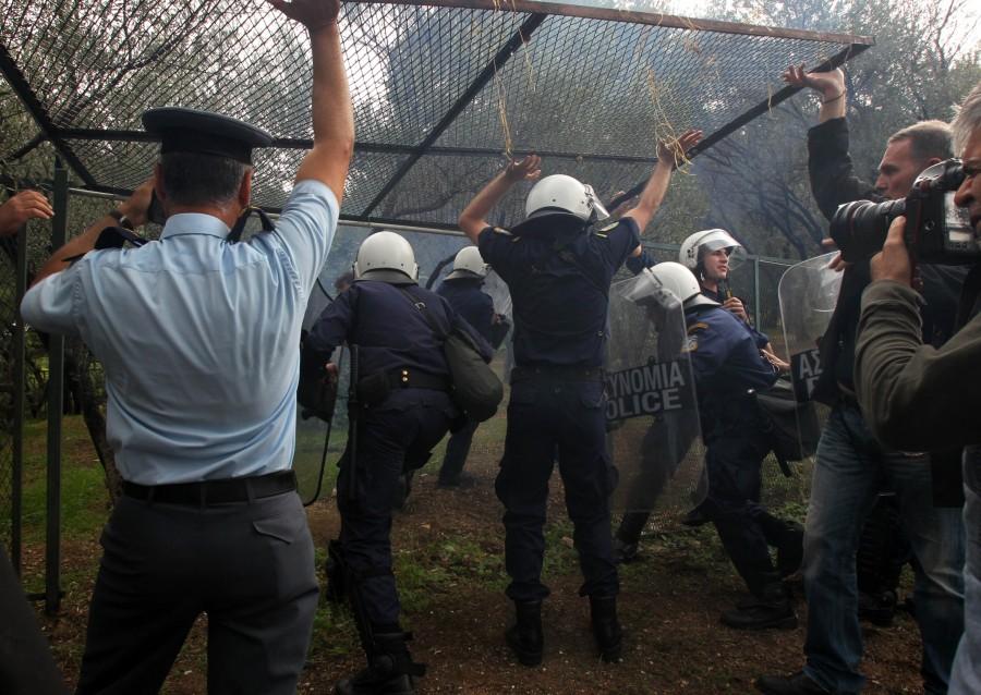 Riot police use a side entrance to enter the compound where they clashed with protesters at the gate of the ancient Acropolis site, Athens' most popular tourist site, which was blocked by angry workers Thursday, Oct. 14, 2010. Police used tear gas to reopen the entrance of the monument. Culture ministry workers on short-term contracts are pressing the government to renew their contracts and are seeking backpay.