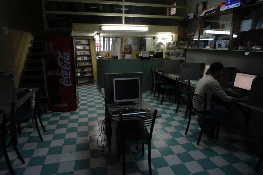 a Palestinian man uses a computer at an Internet cafe in the West Bank city of Bethlehem. A mysterious blogger who set off an uproar in the Arab world by claiming he was God and hurling insults at the Prophet Muhammad is now behind bars, caught in a sting that used Facebook to track him down. 