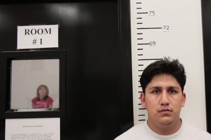 In this Nov. 10, 2010 photo, a suspect in what authorities believe was a major human smuggling ring responsible for the transportation of thousands of illegal immigrants from the U.S.-Mexico border to Phoenix and other parts of the country, is processed in a detention facility in Phoenix.