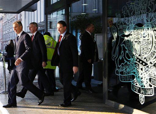 Former British Prime Minister Tony Blair, left, accompanied by his bodyguards, leaves the inquiry into the Iraq war, after giving evidence for the second time in London Friday, Jan. 21, 2011. Blair returned to testify for a second time before a five-member panel scrutinizing Britains role in the unpopular war - having been recalled after witnesses raised doubts about sections of his testimony at an initial appearance a year ago.