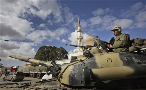 A pro-Gadhafi Libyan soldier sits atop an armoured vehicle next to a mosque in Qasr Banashir, southeast of the capital Tripoli, in Libya, Tuesday, March 1, 2011. Government opponents in rebel-held city of Zawiya repelled an attempt by forces loyal to Moammar Gadhafi to retake the city closest to the capital in six hours of fighting overnight, witnesses said Tuesday. 