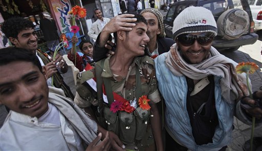 A Yemeni army soldier standing guard along with other soldiers to protect anti-government protestors, is kissed by a demonstrator after receiving flowers, during a demonstration demanding the resignation of Yemeni President Ali Abdullah Saleh, in Sanaa,Yemen, Wednesday, March 23, 2011. Yemen's parliament enacted sweeping emergency laws Wednesday after the country's embattled president asked for new powers of arrest, detention and censorship to quash a popular uprising demanding his ouster.