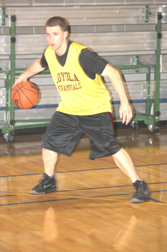 Loyola Alumnus and member of the Phi Psi intramural basketball team Eric Walsh dribbles the ball at the March 29 game against Black Mambas. Phi Psi lost the game 58-53.