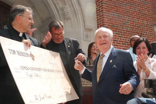 Tom Benson, owner of the New Orleans Saints, signs an $8 million check to Loyola for the Jesuit Center in fall 2010. Plans for the building are not final.