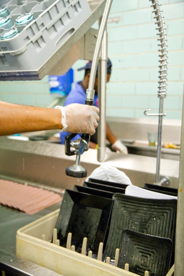 Workers in the Orleans Room wash dishes on the new wraparound conveyor belt dishwashing system during dinner Wedensday, Jan.23. 