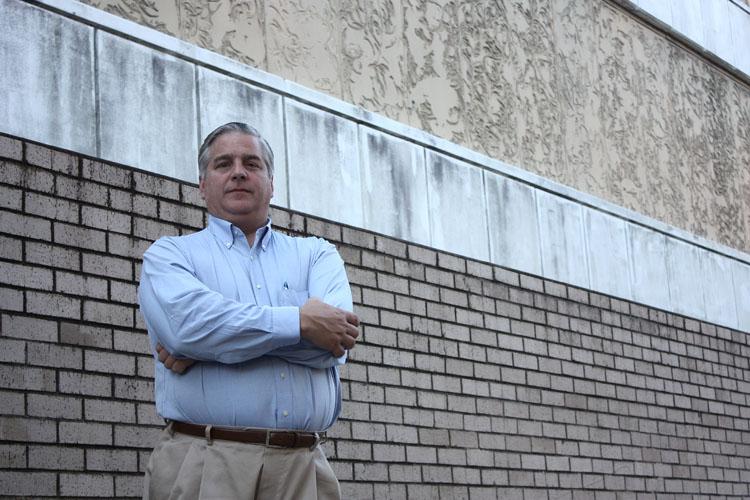 John Fenn French stands next to the windowless side of Monroe Hall along Calhoun Street last October.