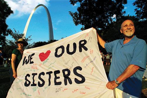 Joe Koerner and his wife Maria Allen Koerner, of St. Louis, rally with other supporters of The Leadership Conference of Women Religious at a vigil Thursday, Aug. 9 in St. Louis. The conference is the largest U.S. group for Roman Catholic nuns and they are meeting to decide how they should respond to a Vatican reform. The organization represents about 80 percent of the 57,000 U.S. sisters.