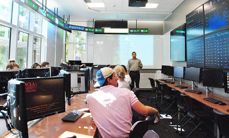 Economics professor John Levendis teaches finance students the basics of investing in stocks portfolio management in Miller Hall’s Carolos M. Ayala Stock Trading Room. Levendis uses an online environment where students can buy and sell stocks.