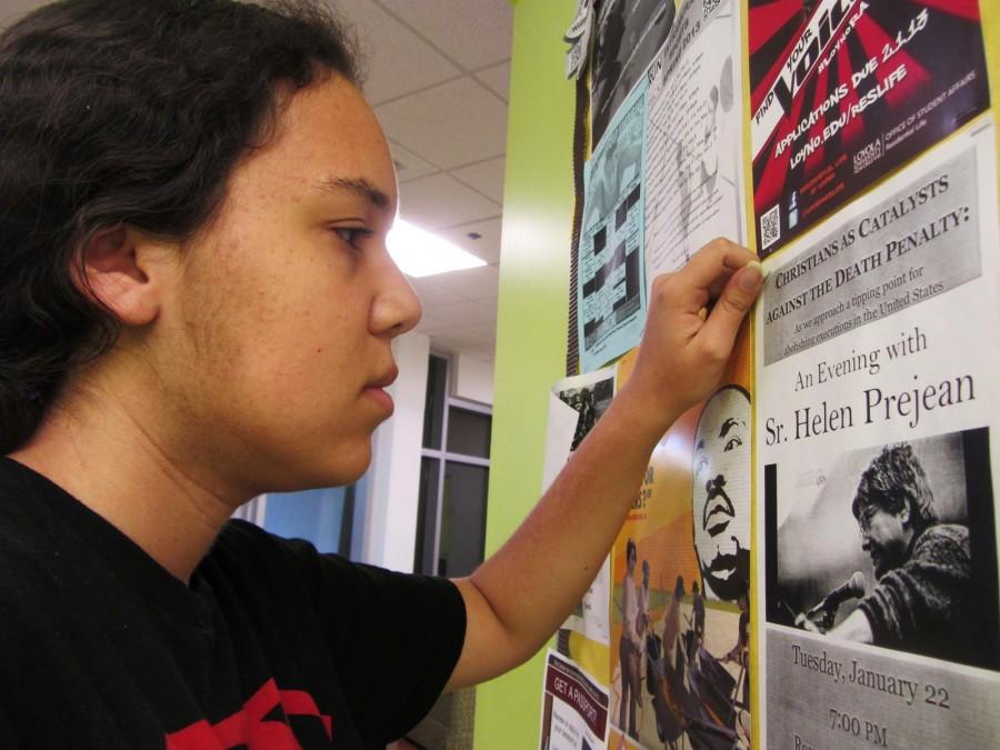 Psychology sophomore Destiny Simms reads a flier posted in Buddig Hall. Starting this semester, four fliers per organization will be permitted to be posted at the entrance of each residence hall, following their approval by Residential Life.