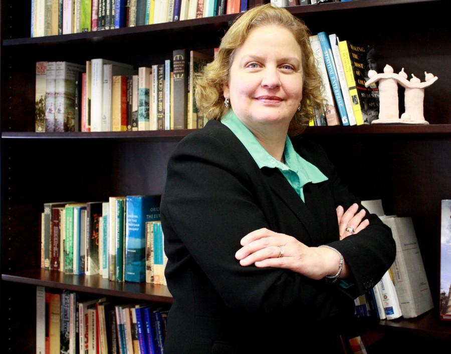 Maria Calzada, professor of mathematical sciences, poses in front of her bookshelf. Calzada will assume the role as permanent dean of the College of the Humanities and Natural Sciences. 