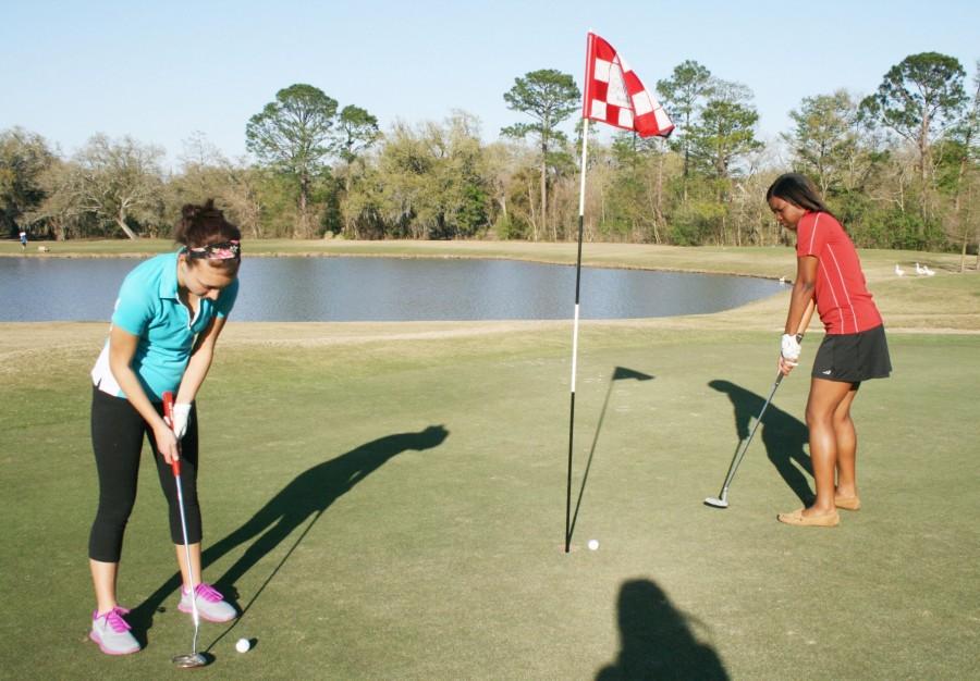 Freshman chemistry major Julia Falco and mass communication junior Raven Richard putt the ball at the end of their round. The two enjoy the challenge that golf brings.  