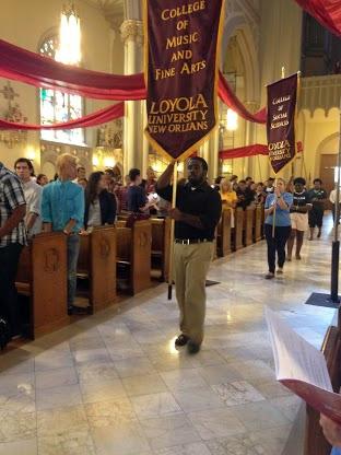 Daniel Sampson, music education senior; Sarah Sewell, political science junior; Terri Zehyoue,  criminal justice junior; and Jasmine Barnes, SGA President and mass communication senior, carry a banner down the aisle of the Holy Name of Jesus church for the beginning of the Mass of the Holy Spirit. All 11 a.m. classes were cancelled on Thursday, Sept. 12, so students could attend and participate. 