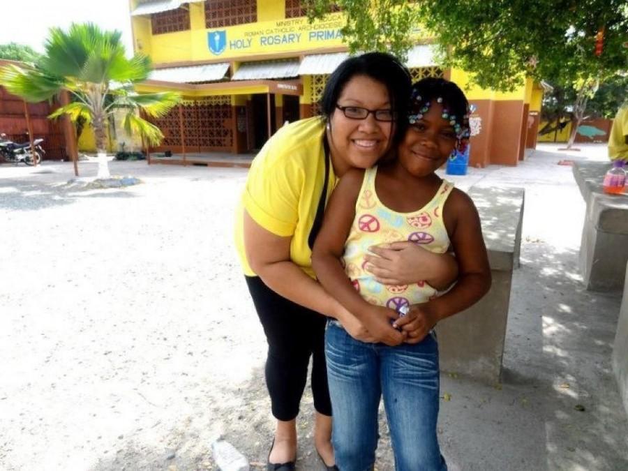 Heather Malveaux, director of Immersion Programs for University Ministry, hugs a Jamaican student from Holy Rosary Primary School. In Jamaica, Ignacio Volunteers cared for the destitute and dying and helped teach in primary schools. 