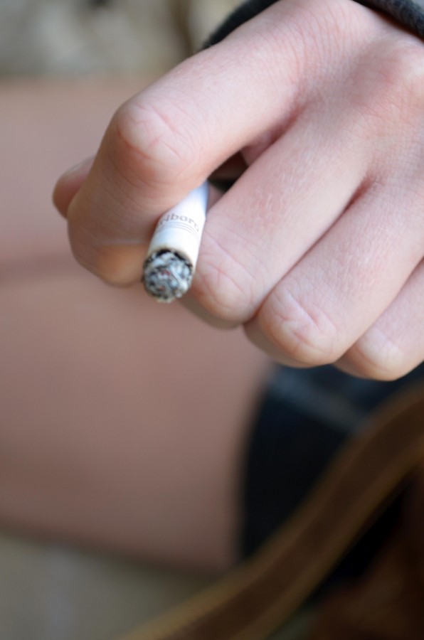 A student lights up a cigarette. Loyola's campus is now non-smoking