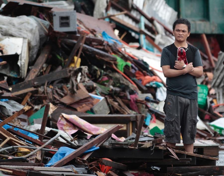 A resident looks at houses damaged by Typhoon Haiyan, in City of Tacloban Leyte province, central Philippines. Haiyan, one of the most powerful typhoons ever recorded, slammed into central Philippine provinces Friday, leaving a wide swath of destruction.