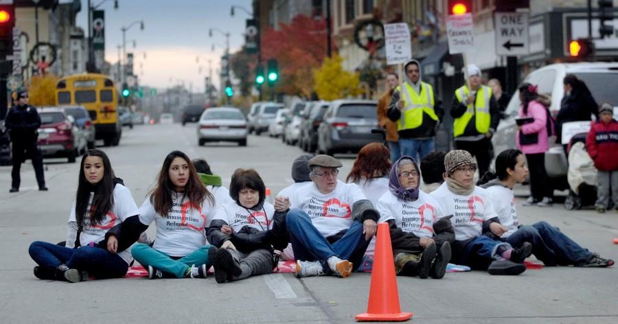 Twelve women hold hands in a circle Friday, Nov. 8, blocking Sixth Street during an immigration reform protest outside Congressman Paul Ryan’s office in Racine, Wis. The new immigration reform Loyola University Community Action Program project at Loyola aims to advocate for the human dignity of U.S. immigrants.