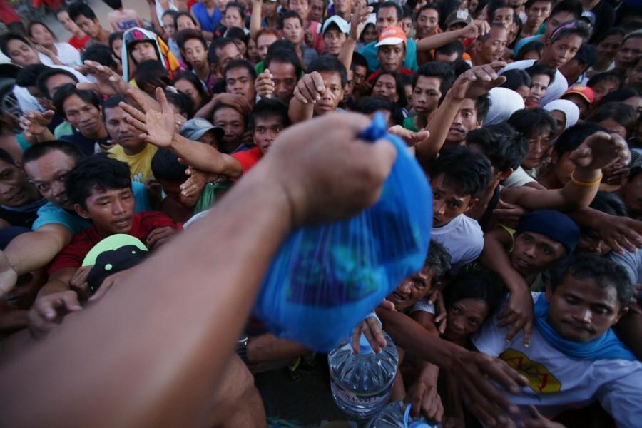 Survivors reach for relief goods from a private group in Tacloban, Philippines on Monday, Nov. 18. The Loyola community has gathered together over the past few weeks to raise money to give goods and aid to people in affected areas of the Philippines.