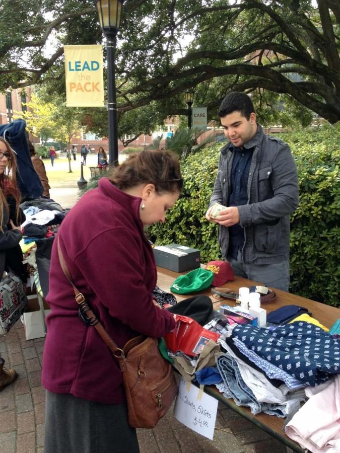 Diane Blair, Loyola Institute for Ministry on-campus services coordinator, purchases a hat from Gabriel Miranda, political science sophomore, at the relief thrift shop.This fundraiser was one event hosted by student groups.