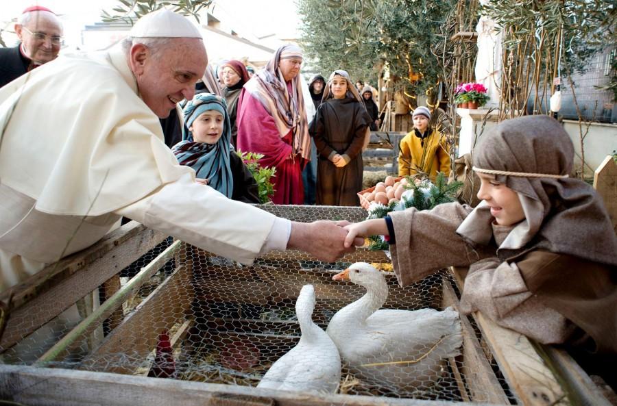 Pope Francis visits a staged Nativity scene at the St. Alfonso Maria de’ Liguori parish church, in the outskirts of Rome. Pope Francis has made a point of interacting with youth in his papacy.