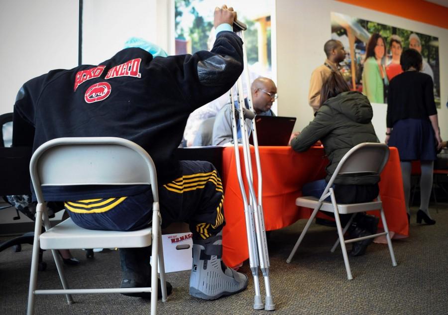 A man with crutches signs up for health coverage at a Connecticut insurance company on March 31, the deadline to sign up for health care under the Affordable Care Act. Despite problems with the website, a late wave of enrollments pushed sign-ups higher than critics believed possible. 