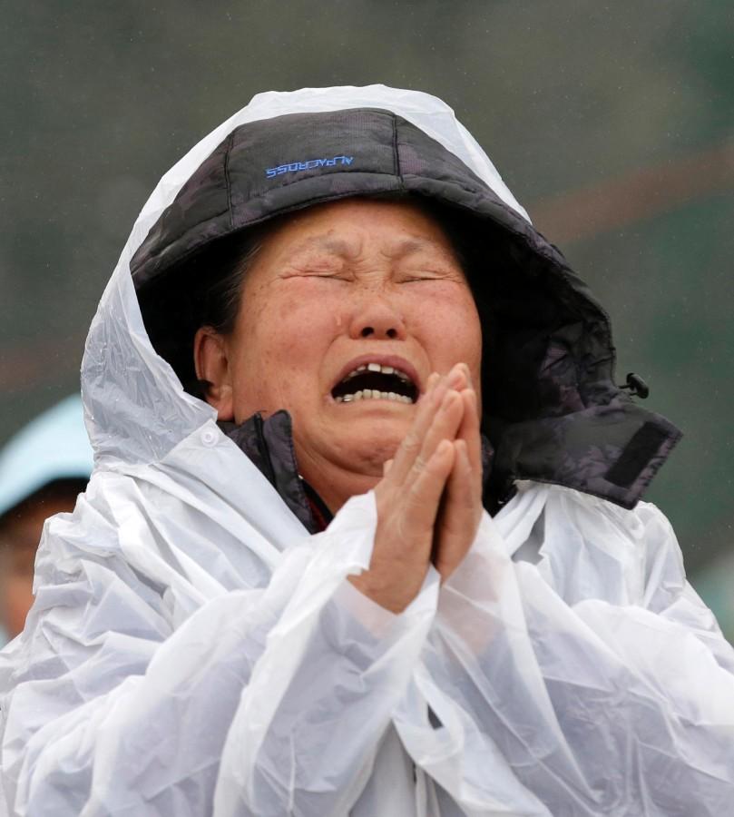 A relative of a missing ferry passenger prays while crying at the port in Jindo, South Korea.