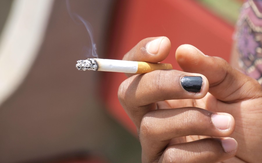 A student smokes a cigarette on Loyola’s campus. A recent initiative has resulted in a complete ban of tobacco products on campus, taking effect Aug 1.