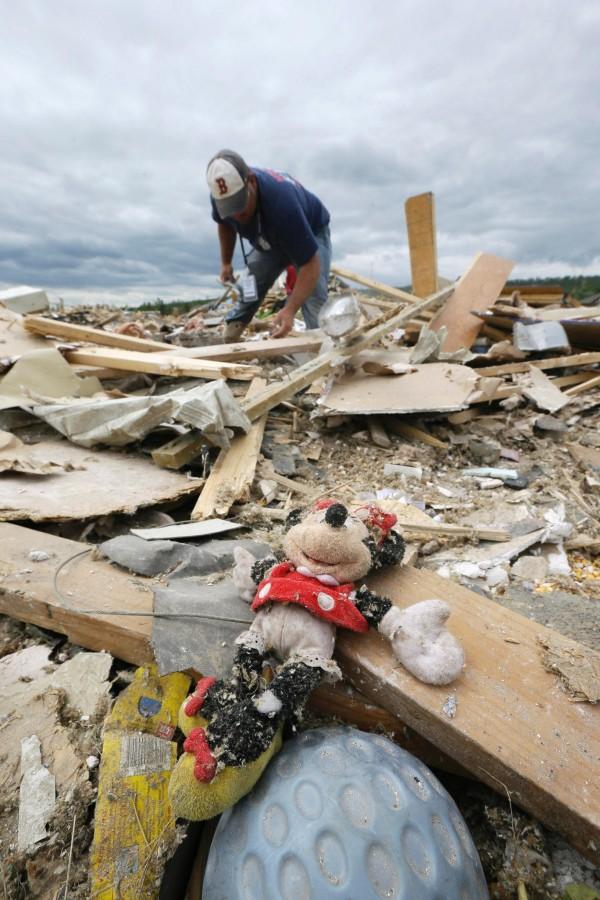 Dustin Shaw searches through rubble of his sister’s home near Parkwood Meadows neighborhood in Vilonia, Ark., Wednesday, April 30, 2014. A tornado struck the town late Sunday. 
