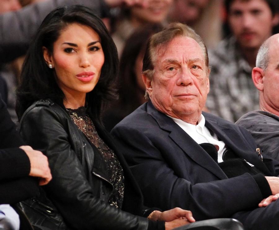Los Angeles Clippers owner Donald Sterling (right) sits with V. Stiviano (left) as they watch the Clippers play the Los Angeles Lakers during a preseason game in Los Angeles. NBA commissioner Adam Silver announced Sterling’s ban from the league on April 29.