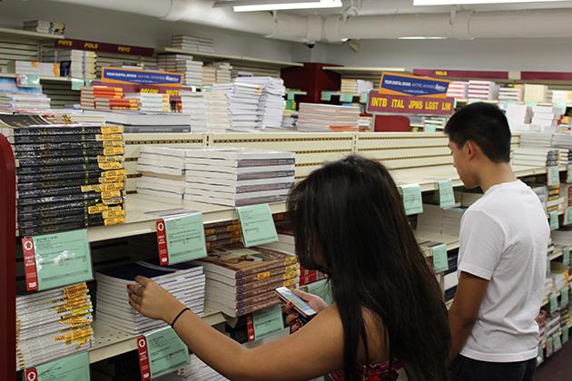 Gina Do, a biology sophomore, searches for the textbooks she needs this semester in the Loyola bookstore. The financial aid office at Loyola is allowing students to utilize excess financial aid money to help cover the costs of textbooks each semester.