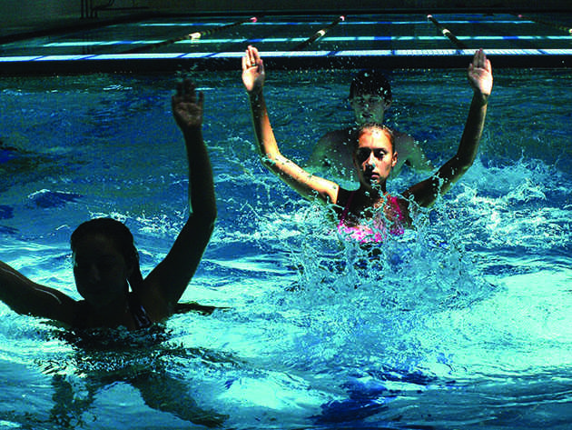 Francesca Vaccaro, biology and chemistry senior, Ashleigh Sparks, visual arts graphics junior and Paul Freese, history senior, perform in-pool exercises for cross-country in the University Sports Complex. Max Shelton, the cross-country teams new coach, has tightened the training schedule and implemented new rules in hopes of getting the team to this years national championships.