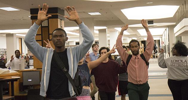 Protestors march through Loyola's library.