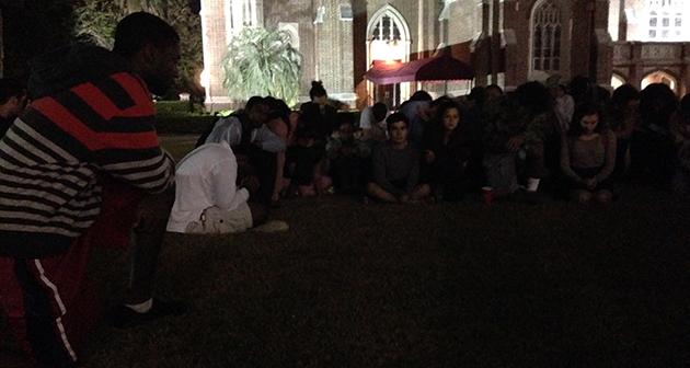 Students gather in silence on Loyolas Marquette Lawn.