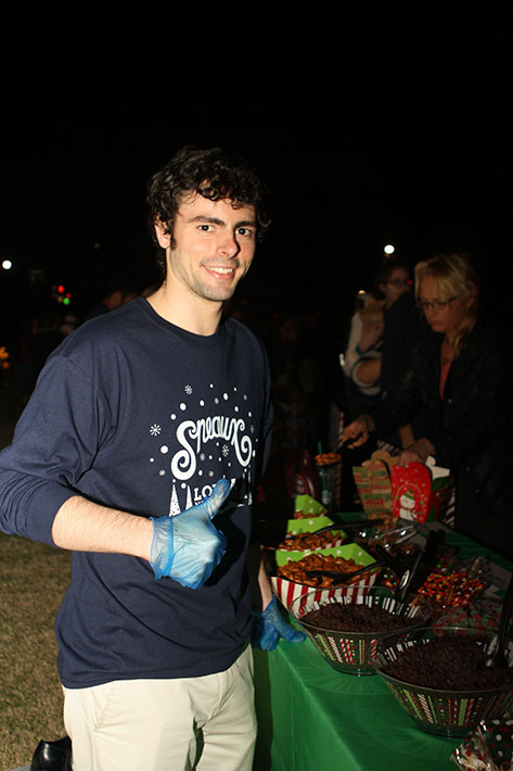 Matthew Moldthan, a physics junior, pauses from serving food to smile for the camera.