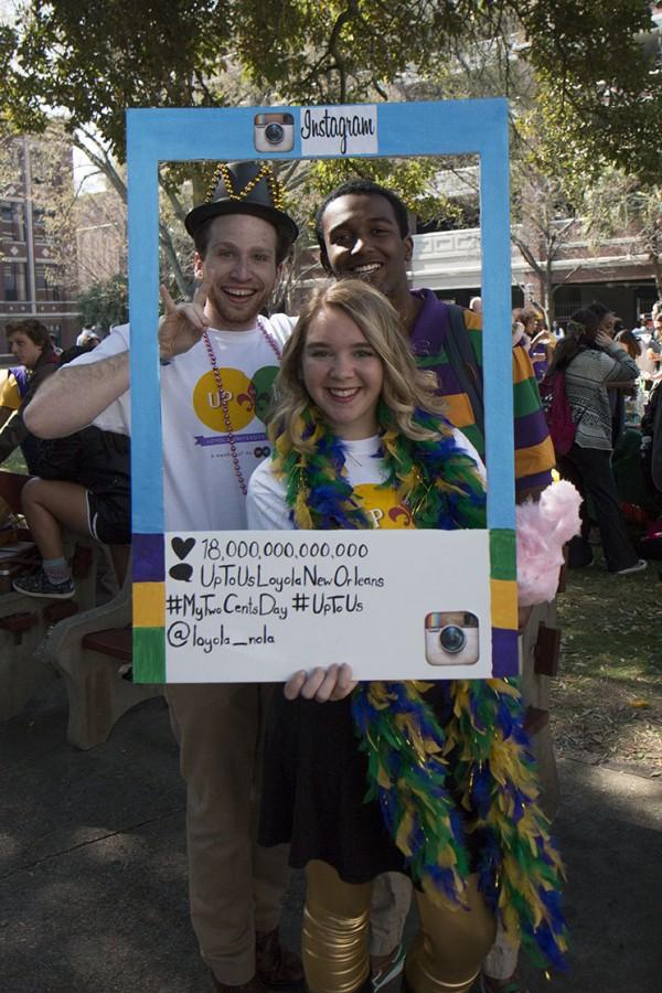 Bud Sheppard, student body president and economics junior, Allison Rogers, political science junior and Ronald Chavis, theater junior, pose with the "Up to Us Loyola New Orleans" sign at Krewe de Lu. "Up to Us Loyola New Orleans" is a campaign designed to make students more aware about the national debt.