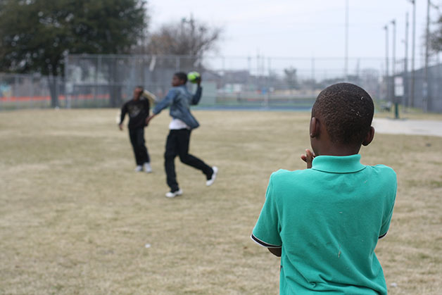E’mond Davis (right) watches on as Lance (center) and John Joiner (left) play football at a playground on Lafitte and N. Prieur streets, where the Lafitte Greenway is planned to unveil. The Greenway is expected to be completed this spring.