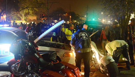 An officer for the New Orleans Police Department and a civilian  jump-start a vehicle.