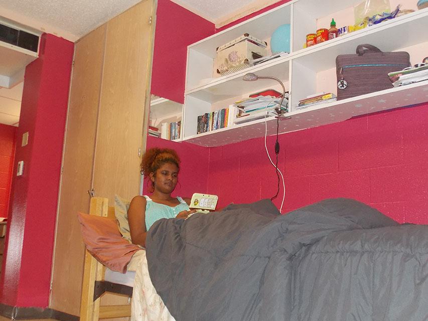 Sophomore Asia Stoll, an international business major relaxes in bed after a long day of classes. Stoll painted her room Raspberry Glaze because of the new Paint Your Own Room program in Buddig Hall.