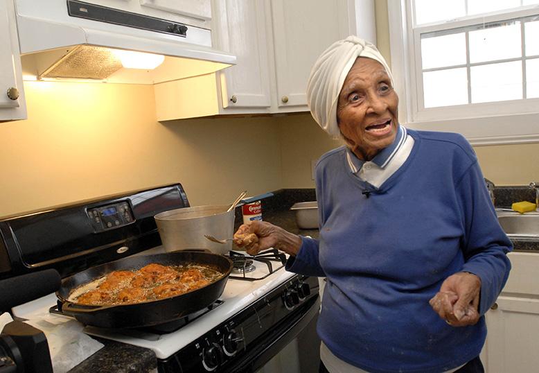 FILE - In this March 4, 2007, file photo, Willie Mae Seaton cooks fried chicken for volunteers helping to rebuild her Hurricane Katrina-devastated restaurant, Willie Maes Scotch House, in New Orleans. Seaton, a chef recognized for her classic American food and whose neighborhood restaurant helped put fried chicken on the culinary map, has died at 99. (AP Photo/Cheryl Gerber, File)