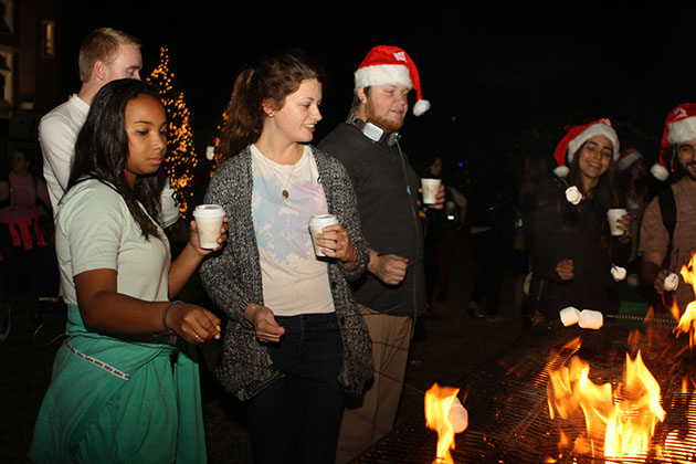 Cierra Guerin, business marketing freshman, Mairead Cahill, mass comm freshman and Zac Roegiers, music industry freshman, make smores as part of Sneaux in 2014. This year's event will take place on Wednesday, December 9th in the horseshoe at 6 pm. (File Photo) Photo credit: Linda Hexter