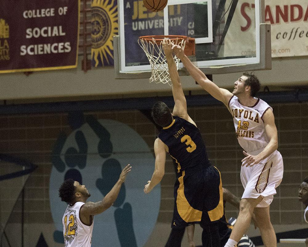 Junior guard Nate Pierre blocks a shot in the second half of the game against Blue Mountain College in the Den. The men blocked four shots in their 54-46 victory.