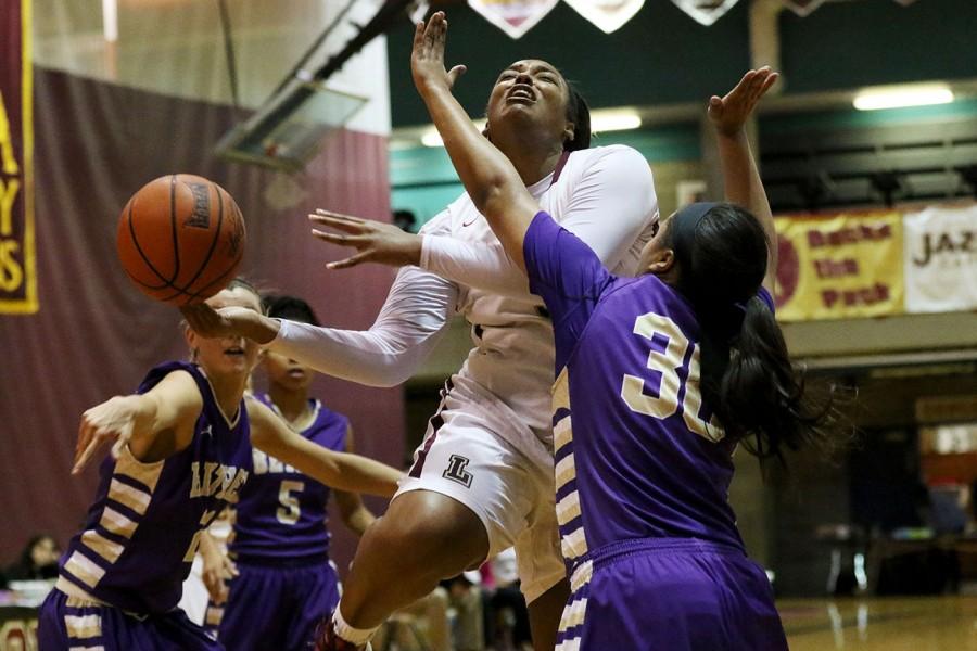 Meghan Temple, Loyola junior forward, has the ball swatted from her hand by Shamon Pearson, left, Bethel University sophomore guard, during the first half of their game in the Den. Bethel University, which is ranked no. 4 in the NAIA, defeated no. 25 Loyola 71-52.