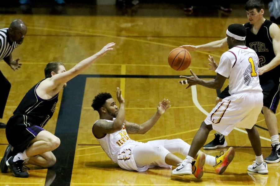 Eric Brown, Loyola freshman guard, passes a loose ball to guard Nick Parker in the second half of their game against SSAC rival Bethel University. The men won their last home game of the season 84-79.