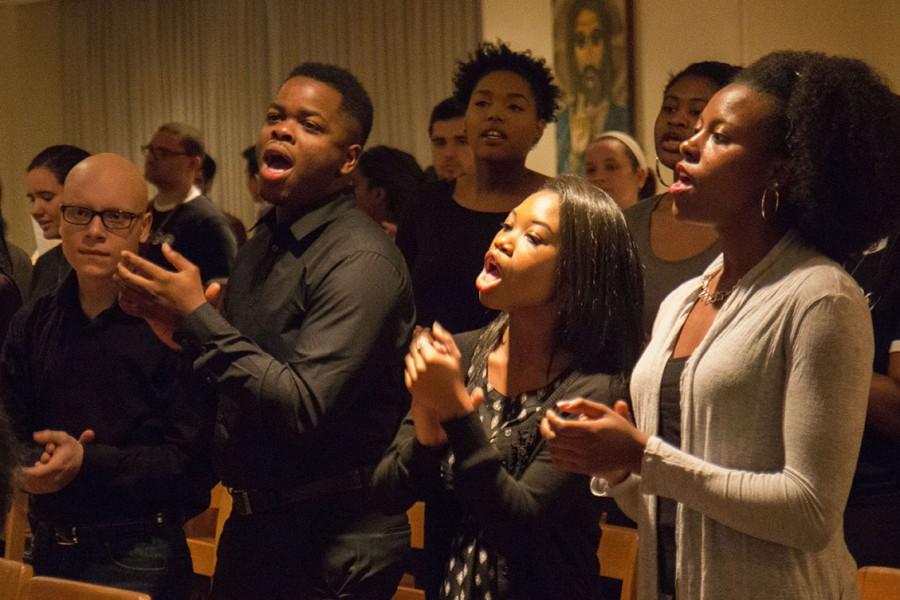 Anthony Pontecore, music industries freshman, left, Joshua Byrd, public relations senior, Johannah Williams, political science sophomore, and Jasmine Coleman, business management senior, right, sing with the Genesis Gospel Choir at the Black History Mass in the Ignatius Chapel on Sunday, February 14th.  The mass, which was led by the Rev. Maurice Nutt, director of the Institute for Black Catholic Studies at Xavier University in New Orleans, focused on Black history in America and Christianity’s role in it. Photo credit: Zach Brien