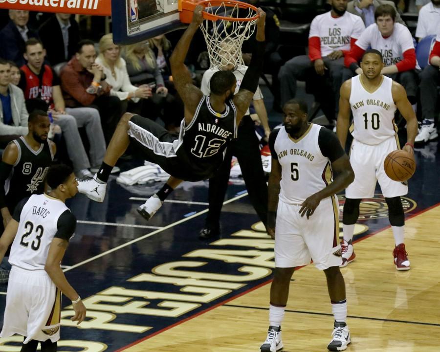 LaMarcus Aldridge hangs on the rim after a dunk in the first half. Aldridge finished the game with 26 points in a 94-86 victory.