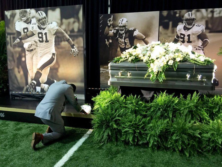 Mourner kneels by Will Smith's coffin