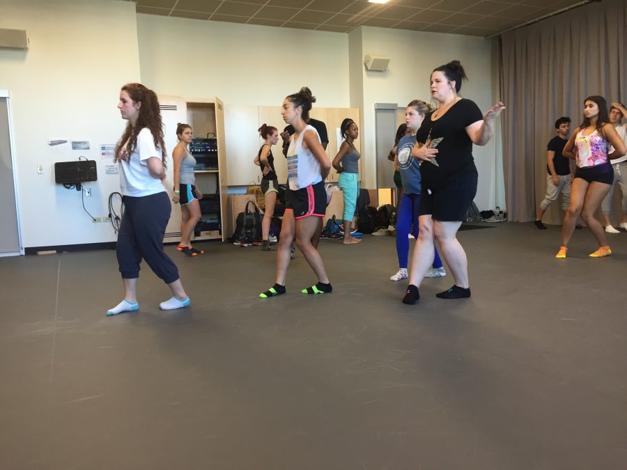 Kadar (in black) demonstrates a Suzuki movement exercise as her class practices.