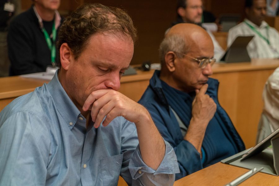 Two Jesuits look over meeting materials in the aula, or meeting room, Oct. 20 at General Congregation 36. The global meeting of Jesuits will make governing decisions for the next several years. Photo credit: Courtesy of General Congregation 36