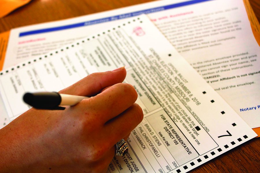 A student fills out an absentee ballot for the November elections. 55 percent of Loyola students can vote absentee this year. Photo credit: Alliciyia George