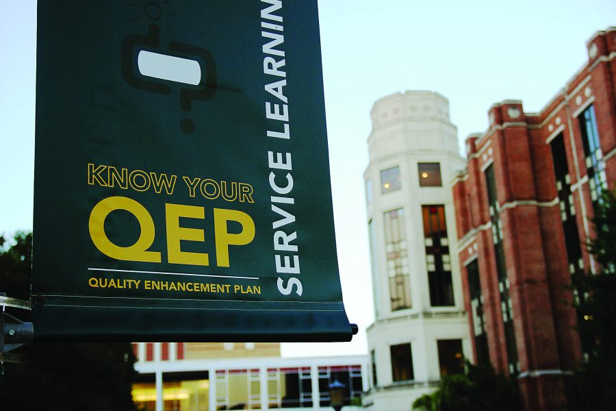 A Quality Enhancement Plan banner hangs from a light post in the Peace Quad early this semester. The plan is already being implemented in some classes, with more to come. Photo credit: Tasja Demel