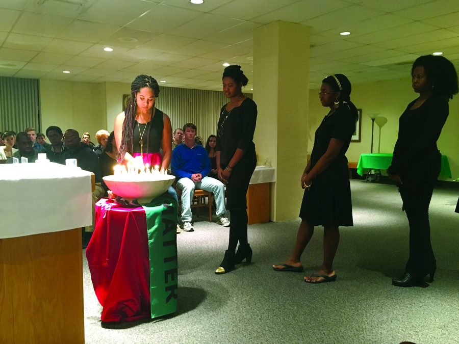 Members of the Genesis Gospel Choir light candles during a litany honoring those lost by police violence. The Mass for Racial Justice was held in Ignatius Chapel on Oct. 23 at 9 p.m. Photo credit: Colleen Dulle